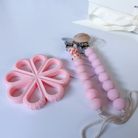 Pink poppy flower silicone teether paired with matching pink beaded pacifier clips, safe baby teething toy and pacifier holder bundle from Bead Sprout.