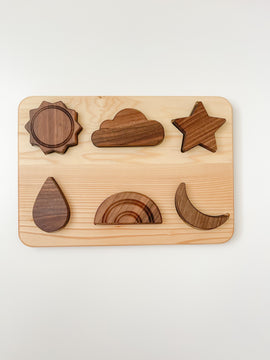 wooden weather puzzle with sun, cloud, star, raindrop, rainbow and moon pieces on a natural linden wood board. 