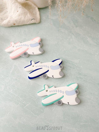 Airplane shaped baby teether in Pink, Navy or Pint color. Silicone baby teether. Meets CPSC Safety Requriements