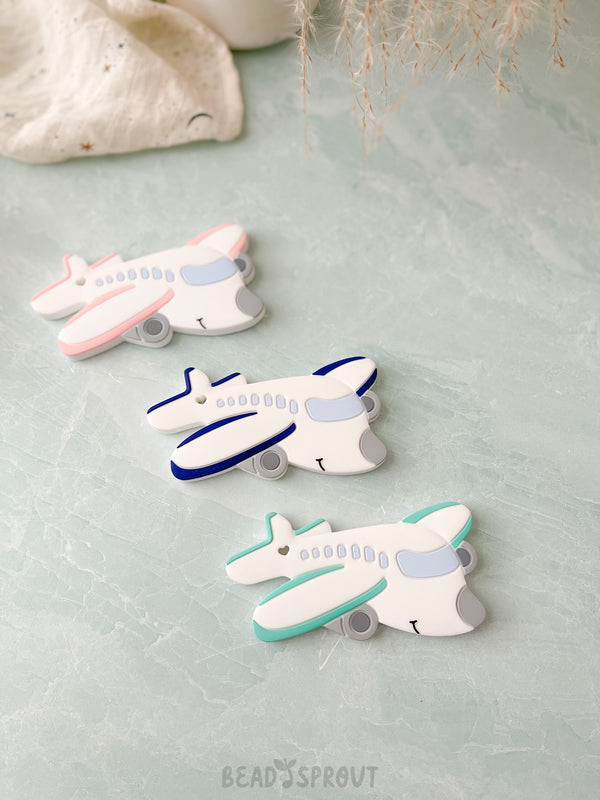 Airplane shaped baby teether in Pink, Navy or Pint color. Silicone baby teether. Meets CPSC Safety Requriements